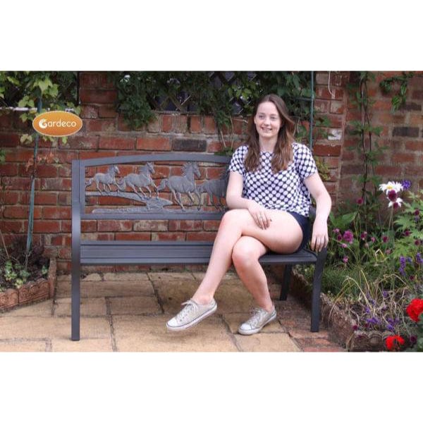 Gardeco Steel Framed Cast Iron Bench With Horses In A Garden Setting With A Girl Sitting On It | SKU: BENCH-HORSES | Barcode: 5031599039435