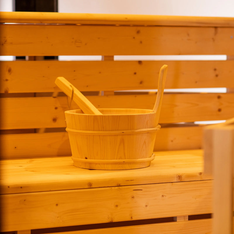 Wooden bucket and ladle on a wooden bench of a steam sauna