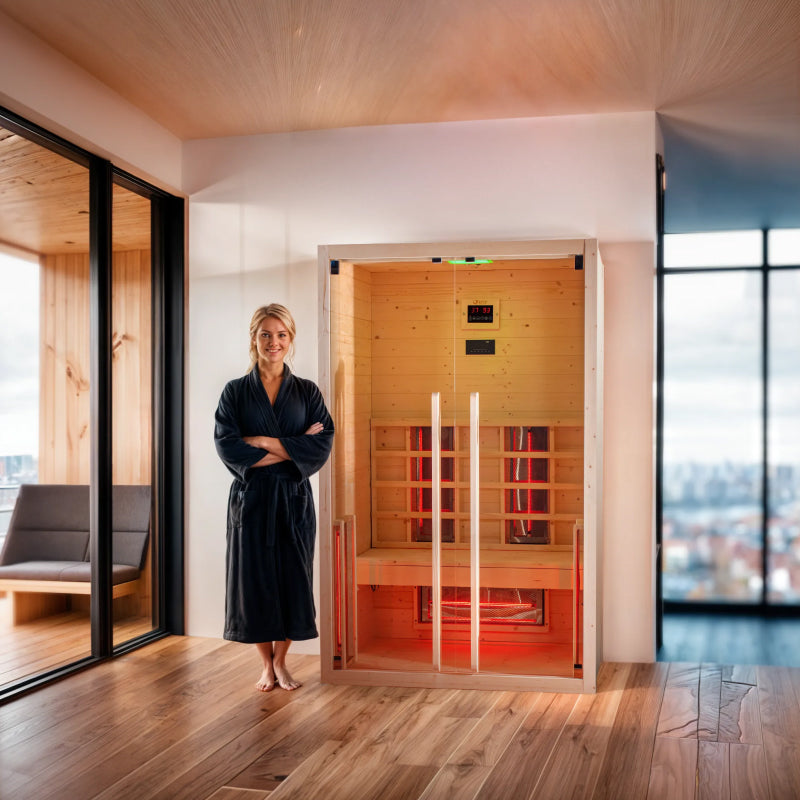 Woman in a black robe standing in front of Dharani S2 infrared sauna in a modern room with large windows.