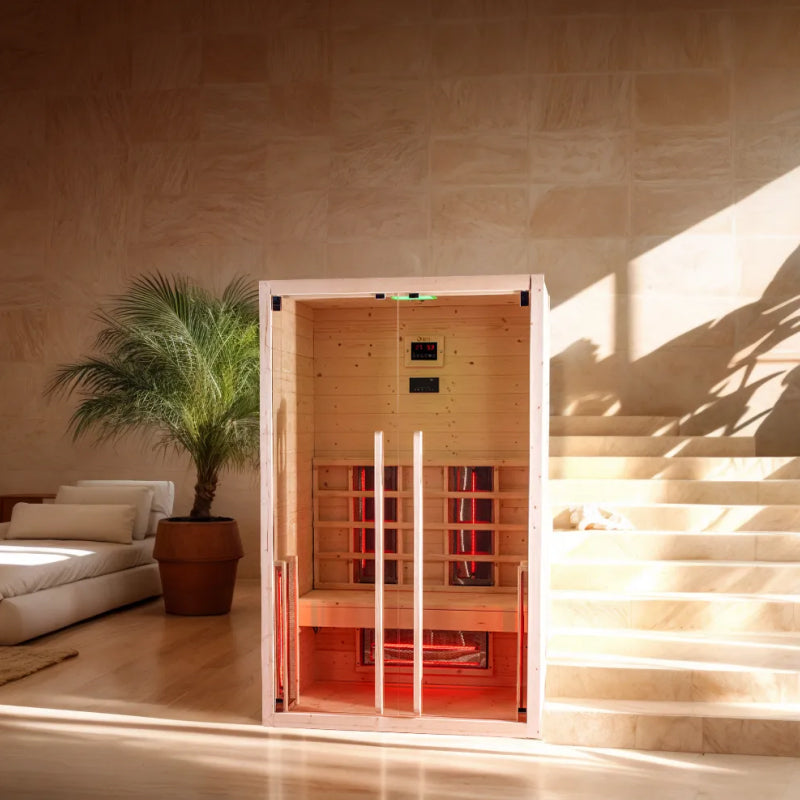 Dharani S2 infrared sauna in a room with a couch and a plant.