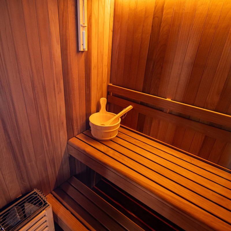 Wooden sauna with a bench and a basket with a brush inside