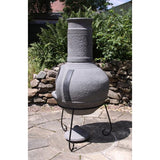 Side View On Gardeco Linea XL Mexican Chimenea In Grey In A Sunny Garden Setting | SKU: C6L.46 | Barcode: 5031599047362