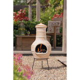 RedFire Star Flower Clay Chiminea / Outdoor Fireplace In Straw Colour With Burning Logs Inside In A Garden Setting | SKU: 411837 | Barcode: 8718801854754