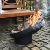 Esschert Design Black Steel Sloping Fire Bowl With Burning Logs In A Garden Setting | SKU: 422496 | UPC: 8714982142727