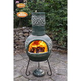 Gardeco Large Green Edyth Mexican Chiminea In A Celtic Theme With Burning Logs Inside In A Garden Setting | SKU: C21E.03 | Barcode: 5031599051062